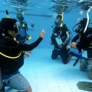 Ein Tauchlehrer mit seinen Schülern im Pool